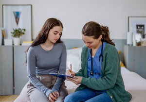 Nurse talks to teen about medication management