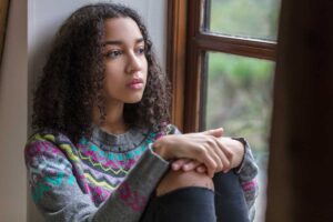 An teen with ADHD is staring out of her window. She is thinking about lying so that she doesn't get into trouble.