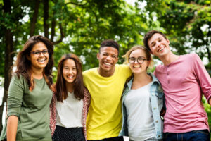 a group of teens smiling outside