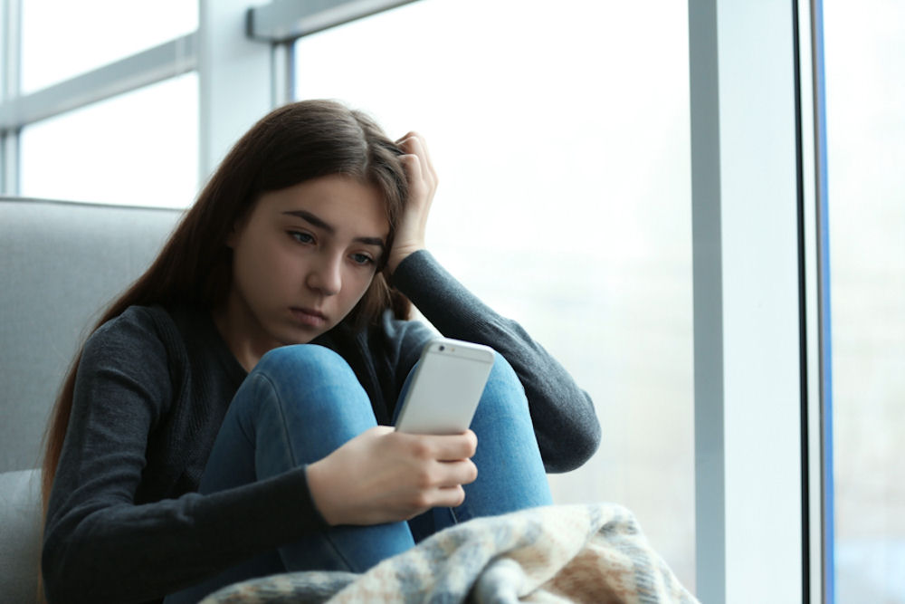 Teen experiencing social anxiety from cyberbullying